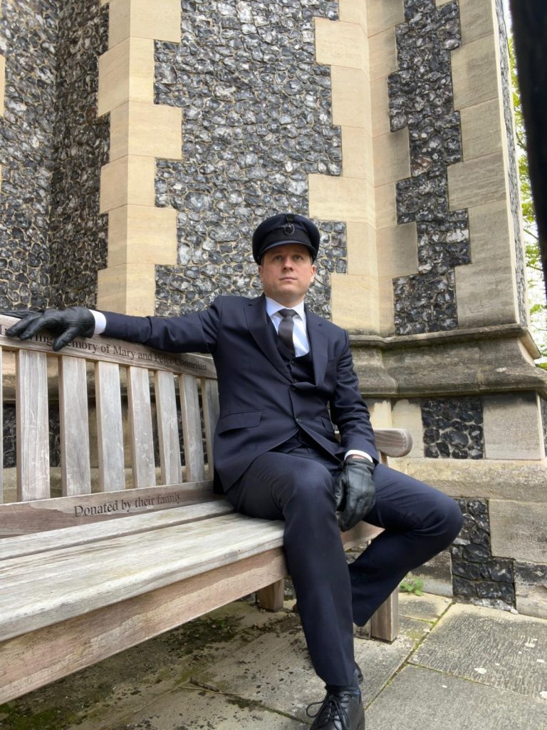 Professional chauffeur assisting bride into luxury wedding car